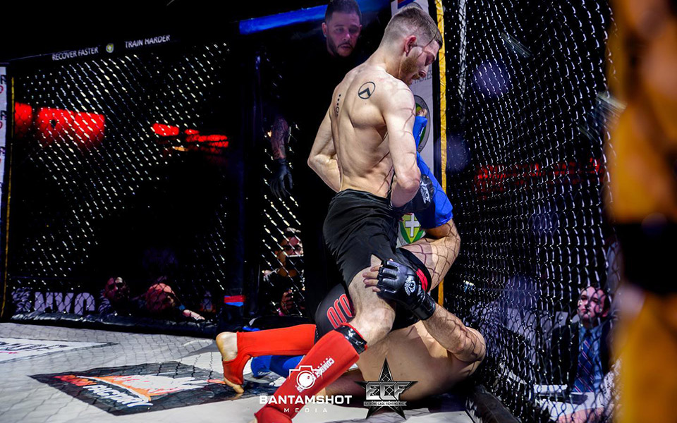 Radical MMA student pressuring his opponent against the cage